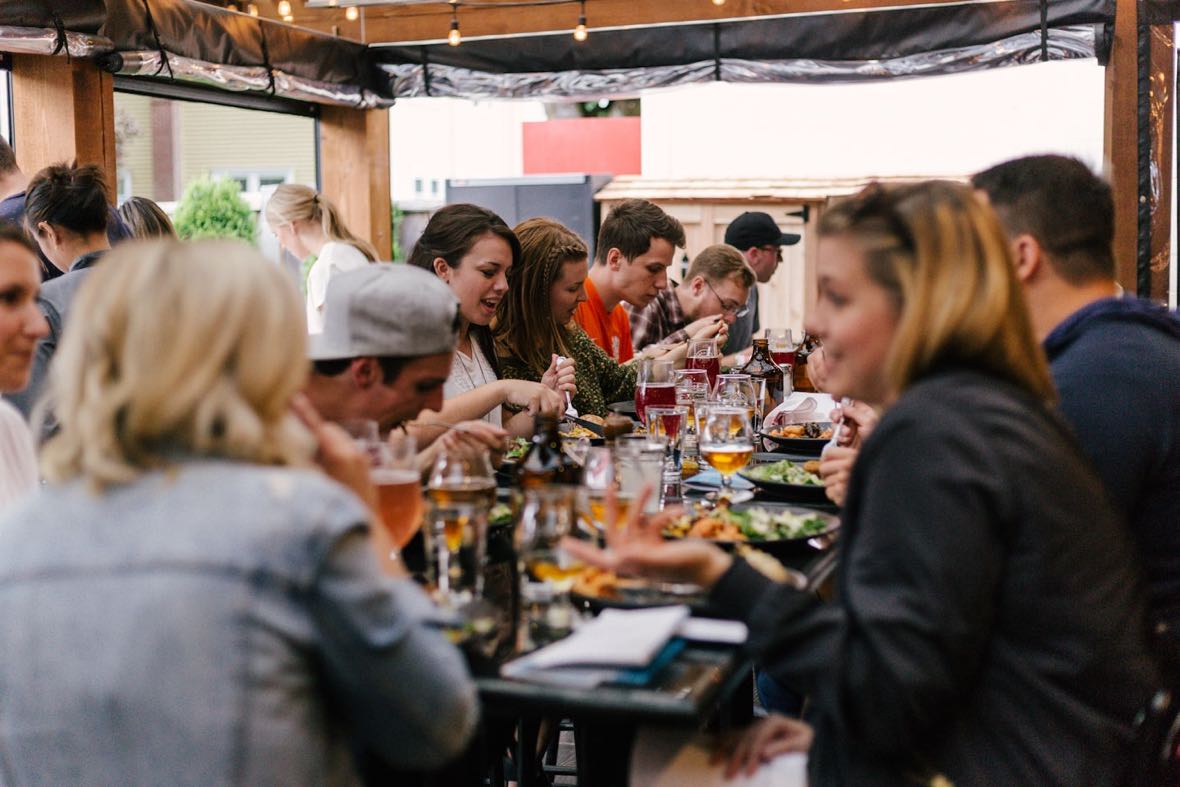Runners sitting together at a long table with food and drinks after a run.